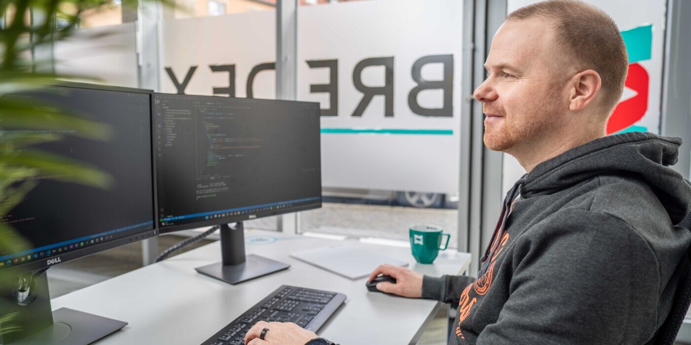 Ein Softwareentwickler arbeitet an seinem Rechner im Büro der BREDEX Gmbh.